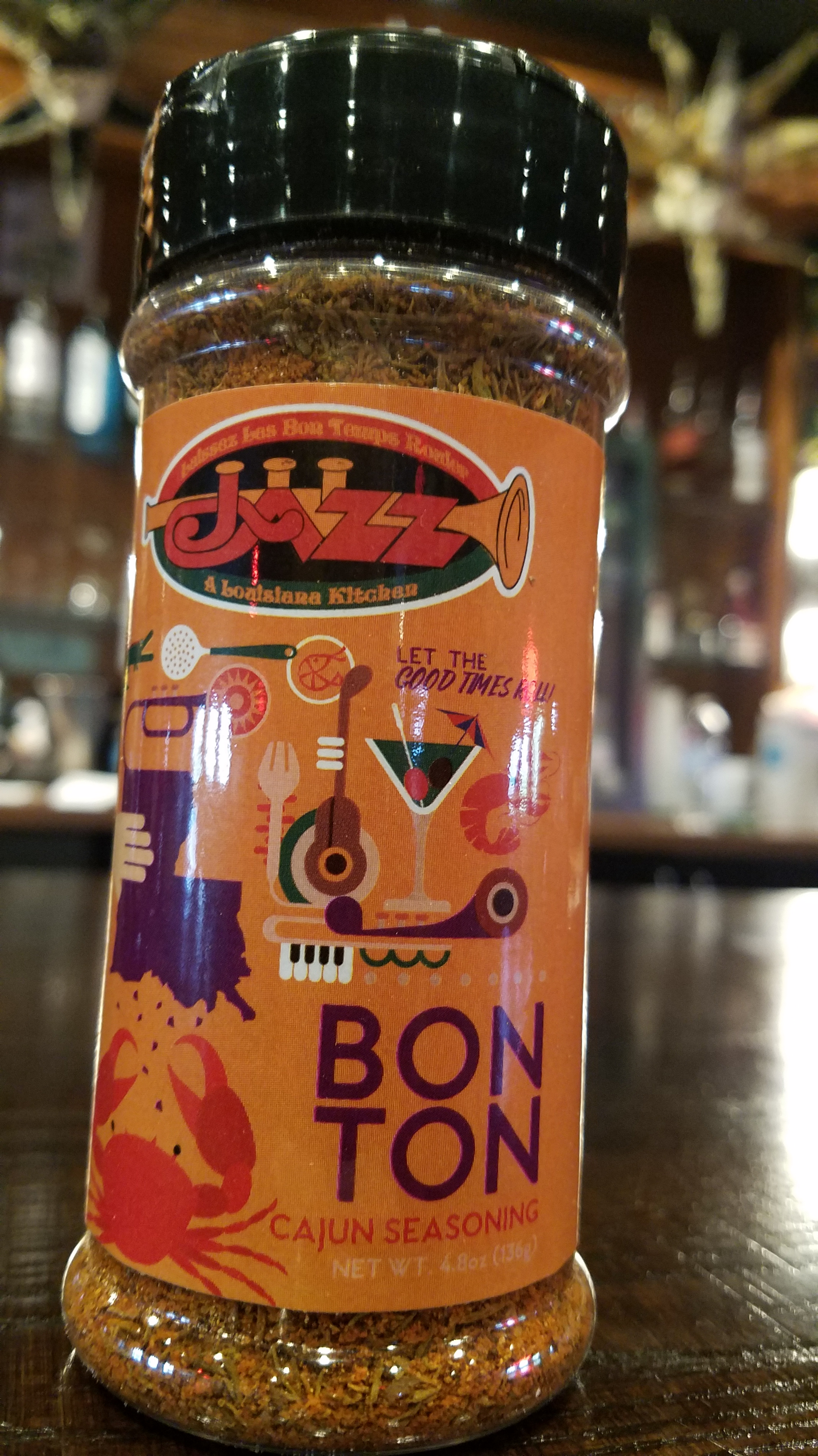 Jazz - A Louisiana Kitchen A bottle of Bon Ton Cajun seasoning on a table, with a festive label featuring a trumpet and crab design. Kansas City, Columbia, cajun food restaurant near me
